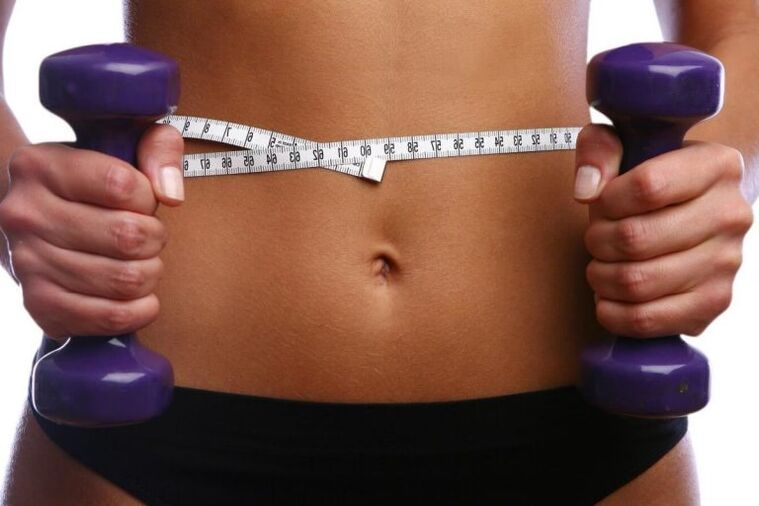 Fitness dumbbells in the hands of a fitige girl